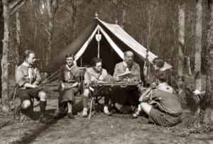 Le Père Sevin, à Chamarande, devant une tente, dans les bois. Entouré de cinq personnes, dont André Noël et Vera Barclay.