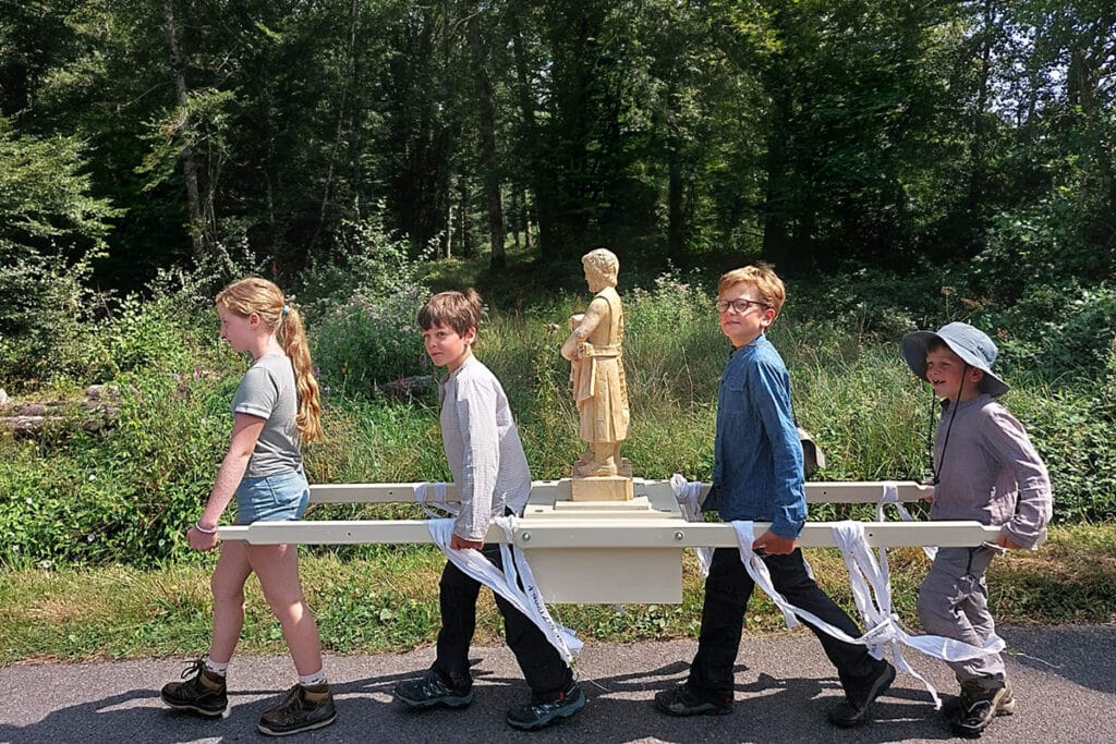 4 jeunes pèlerins portant la statue de saint Joseph.